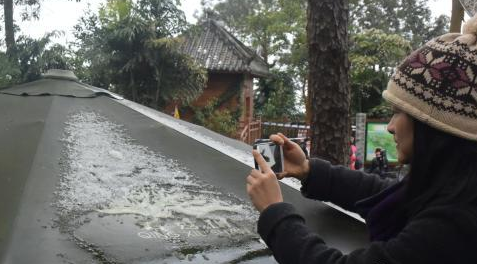 摄影爱好者爬上高处拍摄遮阳伞上的积雪