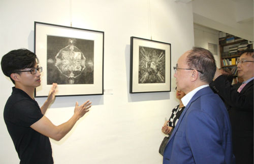 方伟向参展者介绍作品，该幅画作曾在2015年于北京鸟巢展出（摄影：吴玉洁）