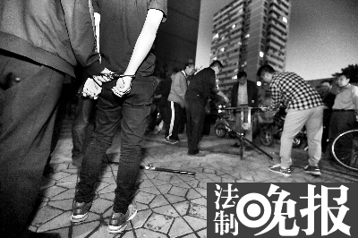 执法人员带嫌疑人在芳群园小区指认现场  摄/记者 柴程