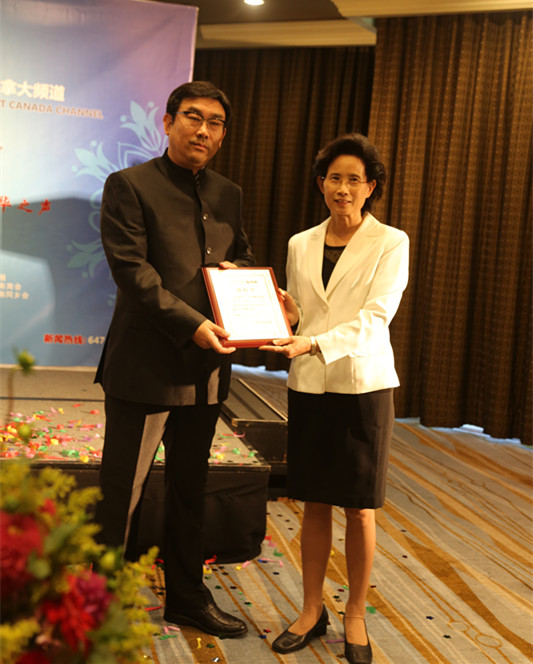 1473473462312335.jpg 人民日报海外版副总编辑刘玉琴为加拿大频道执行总编、中华传媒集团董事长常建国授牌。(吕文宝 摄).jpg