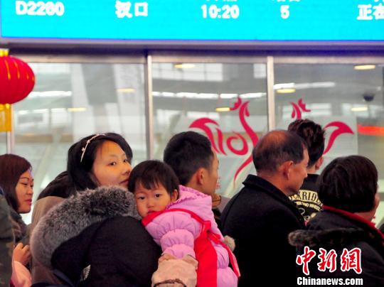 一名儿童在母亲的怀抱中候车。吴正琪摄