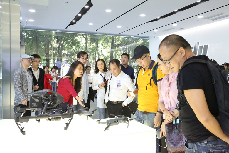媒体采访团认真听取工作人员介绍大疆无人机产品.jpg
