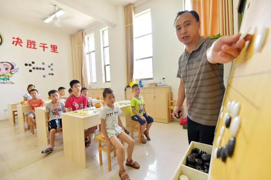 △2018年，江西省一青少年校外活动中心学生正在听老师讲解围棋技法。