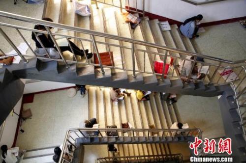 图为考研生坐在楼梯上专心背诵。孙宏瑗 摄 图为考研生坐在楼梯上专心背诵。孙宏瑗 摄
