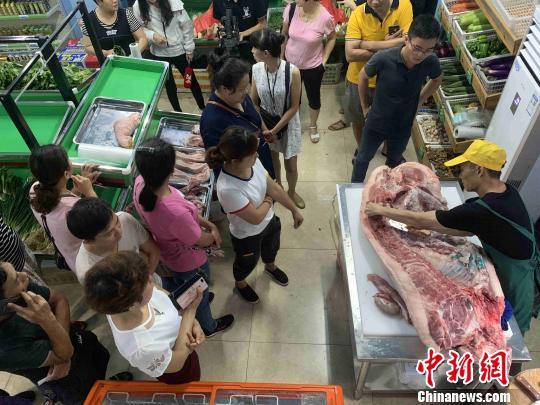 资料图：市民在海口市菜篮子销售点购买“放心猪肉”。王子谦 摄