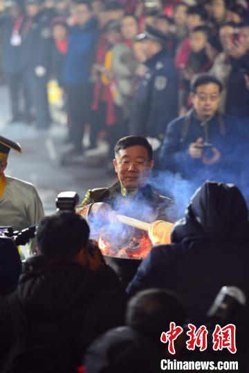 秦玉峰点燃火把，让国家级非物质文化遗产东阿阿胶制作技艺的传人们传递。邱江波 摄