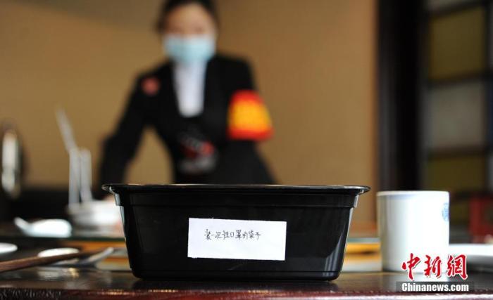 资料图：一家餐饮店为食客准备了存放一次性口罩的塑料袋。a target='_blank' href='http://www.chinanews.com/'中新社/a记者 刘忠俊 摄