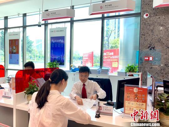 资料图：银行工作人员正在为客户服务。赵玎 摄