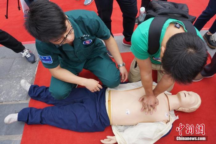 资料图:一位学生在志愿者的帮助下学习心肺复苏术。 董晓斌 摄 资料图:一位学生在志愿者的帮助下学习心肺复苏术。 董晓斌 摄