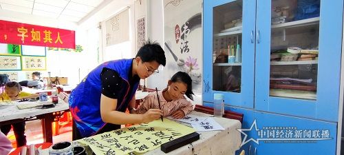 书法班志愿者教师引导学生书写.jpg