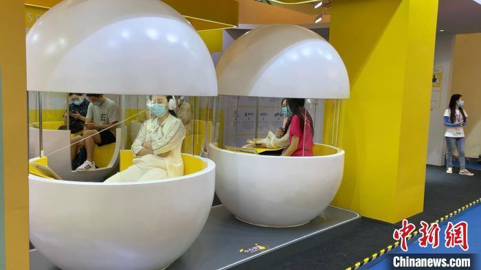 资料图：书展中，读者在“时间胶囊”内感受沉浸式视听体验。周卓傲 摄