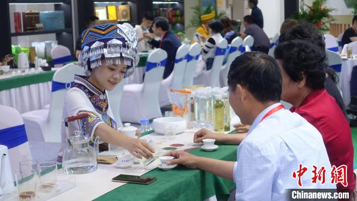 身穿民族服饰的茶艺师为茶商斟茶。钱晨菲 摄