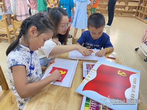 学生党员教小朋友画国旗与党旗.jpg