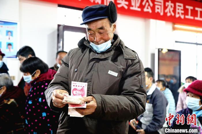 资料图：茶农数钱。邱志烃 摄
