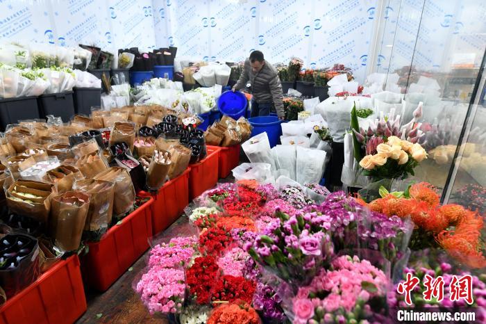 图为:店员正在整理鲜花。吕明 摄 图为:店员正在整理鲜花。吕明 摄