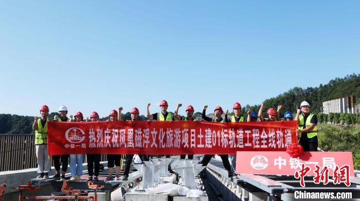 参建人员合影庆祝轨道工程全线轨通。邹娇 摄