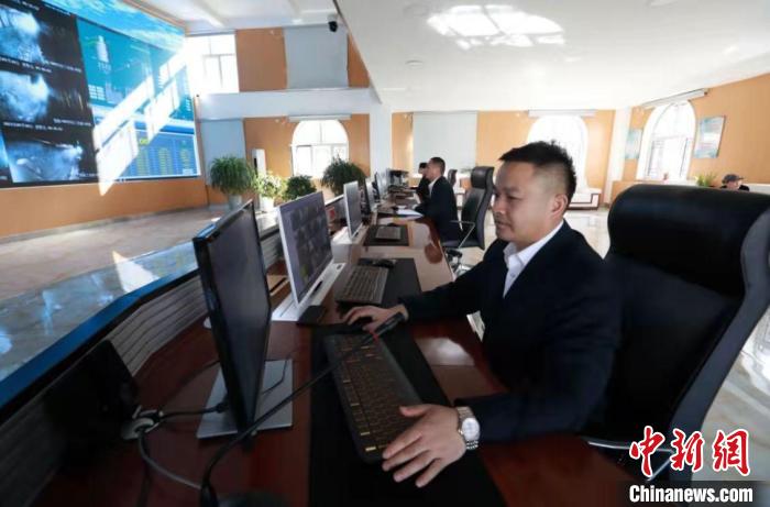 在麻地梁煤矿， 身着白衬衫，坐在宽敞明亮的智能调度集控中心，实现远程“一键采煤”已成为现实。金墨 摄