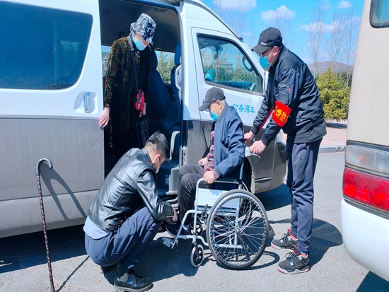 青年志愿者帮助老年人接种疫苗.jpg