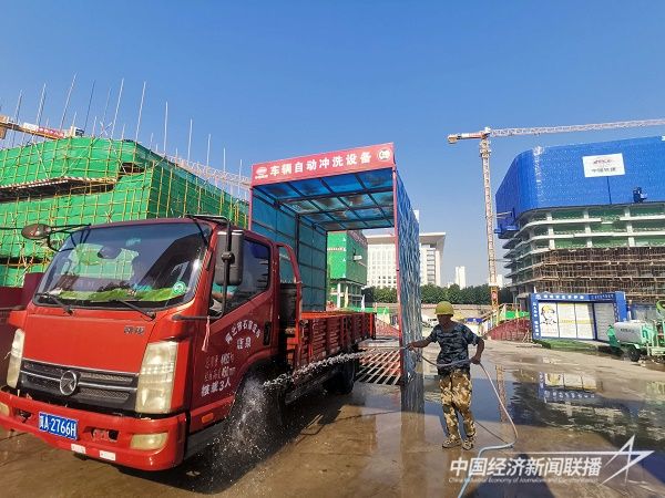 中铁十八局集团北京公司河北项目群建设者在正定汇程国际中心项目通过车辆自动冲洗设备冲洗进出工地车辆（伍振 摄）.jpg?v=1706498308